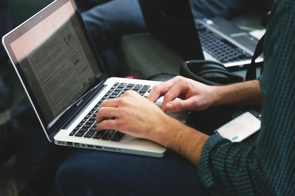 Freelance consultant aan het werk op een laptop in een zakelijke werkomgeving.